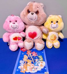 three teddy bears sitting next to each other on top of a blue table with stickers