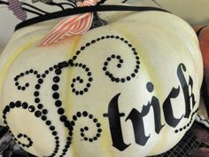 a white pumpkin decorated with the word trick on it