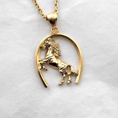 men's horse necklace pendant 1 made in 14k solid gold or 18k solid gold this necklace pendant is a horse with exquisite details in a horse's hoof. - pendant height is 28mm without the bail. - model wears a 2.1mm chain 50cm. - materials: 14k solid gold, 18k solid gold - designed by carre d'or - made in south korea 14k gold horse pendant necklace weight pendant only 7.66g (±5%) with a 2.1mm chain 42cm 13.62g (±5%) with a 2.4mm chain 42cm 15.49g (±5%) with a 3.0mm chain 42cm 19.24g (±5%) 18k gold horse pendant necklace weight pendant only 9.13g (±5%) with a 2.1mm chain 42cm 15.53g (±5%) with a 2.4mm chain 42cm 17.54g (±5%) with a 3.0mm chain 42cm 21.56g (±5%) Classic Horse Design Pendant Necklace, Gold Horse Design Pendant Necklace, Classic Gold Jewelry With Horse Design, Gold Pendant Necklace With Horse Design, 14k Yellow Gold Jewelry With Horse Design, Mens Necklace Gold, Men's Necklace Gold, Heirloom Rings, Horse Pendant