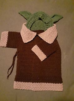 a crocheted baby yoda outfit on a bed