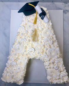 a cake shaped like the letter a with a graduation cap on top