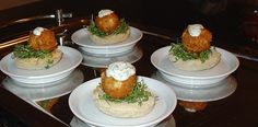 four white plates topped with food on top of a counter