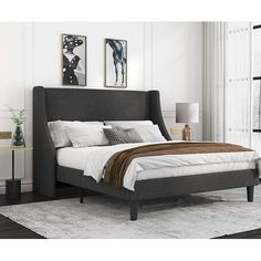 a bedroom with a bed, nightstand and two pictures on the wall above it's headboard