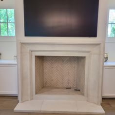 a white fireplace with a tv above it