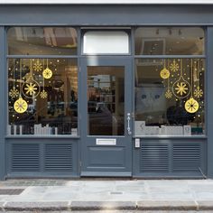 a store front with gold decorations on the windows and door glass doors that are open