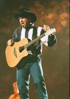 a man with a guitar standing on top of a stage