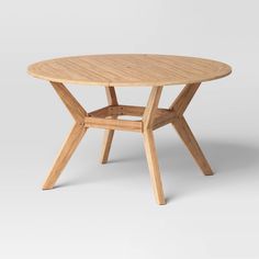 a round wooden table with four legs and a cross - legged design on the top