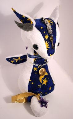 a stuffed animal that is wearing a blue and white outfit with gold stars on it