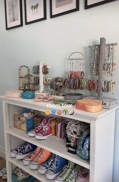 there are many pairs of shoes on the shelf in this room with pictures above them