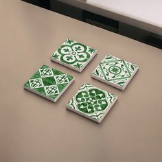 four green and white tiles sitting on top of a table