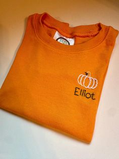 Hand stitched pumpkin toddler t shirt with name.  Font name and color are customizable Personalized Cotton T-shirt For Fall, Fall T-shirt With Embroidered Graphics For School Spirit, School Spirit T-shirt With Embroidered Graphics For Fall, Fall School Spirit T-shirt With Embroidered Graphics, Casual Personalized T-shirt For Fall, Personalized Casual T-shirt For Fall, Embroidered Short Sleeve T-shirt For Fall, Fall Embroidered Graphics Short Sleeve T-shirt, Custom Embroidery Short Sleeve T-shirt