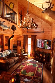 a living room filled with furniture and lots of antlers hanging from the ceiling above