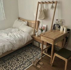 a bed sitting next to a wooden desk on top of a hard wood floor in a bedroom