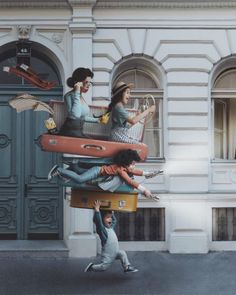 three women are standing on suitcases in front of a building