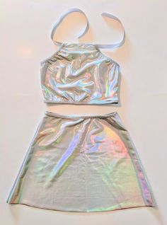 a shiny silver skirt and top on a white surface with a tie around the waist