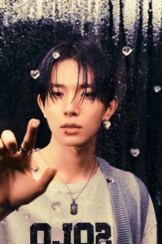 a young man making the vulcan sign with his hand in front of raindrops