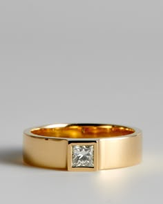 a yellow gold ring with a princess cut diamond