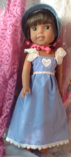 the doll is wearing a blue dress and hat