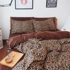 a leopard print comforter and pillows on a bed