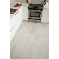 a kitchen with white tile floors and stainless steel appliances