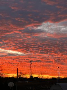 the sky is red and orange as the sun sets