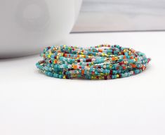 Fiesta No. 4 extra long wrap beaded bracelet. Tiny multi color seed beads boho layering jewelry can be worn as necklace or anklet too. Handmade by Samantha Price at WPshoppe.etsy.com and thewrappepdpixie.com A beachy glass bead bracelet made with my custom color mix of glass seed beads 2mm (11/0) with a few 3mm Czech glass dark beads in the mix. The perfect layering bracelet for any tropical getaway. Layer this glass beaded wrap bracelet with others for a fun flowy look. Details: Fiesta No. 4 To Bohemian Wrap Bracelet With Colorful Heishi Beads, Wrap Bracelet With Faceted Beads For Festivals, Faceted Beads Wrap Bracelet For Festivals, Wrap Bracelet With Faceted Round Beads For Festival, Bohemian Heishi Beaded Waist Beads, Bohemian Wrap Bracelet With Faceted Round Beads, Bohemian Multi-strand Waist Beads With Spacer Beads, Bohemian Multicolor Wrap Bracelet With Tiny Beads, Handmade Bohemian Waist Beads As A Gift