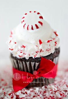 a cupcake with white frosting and red sprinkles