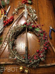 a wooden table topped with christmas wreaths and other decorations