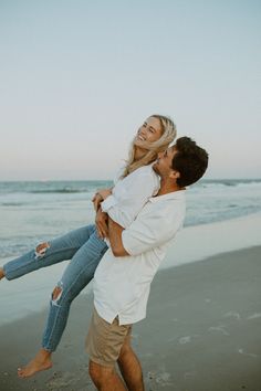 a man carrying a woman on his back at the beach