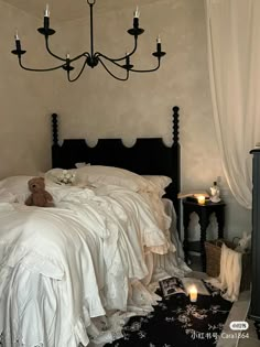 a bedroom with a bed, chandelier and teddy bear on the floor next to it