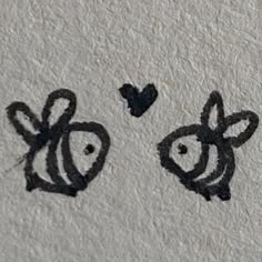 two black and white drawings on the side of a wall next to a heart shaped object