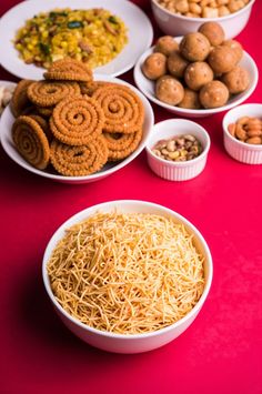 bowls filled with different types of food on top of a red tablecloth covered table