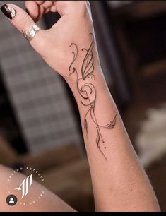 a woman's arm with a tattoo on it and a ring in the middle