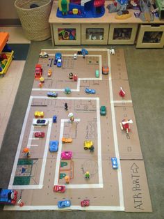 a play area with toy cars and toys on the floor