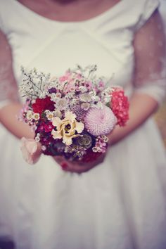 a woman holding a bouquet of flowers in her hands