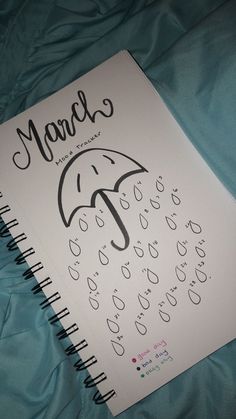 a notebook with an umbrella drawn on the front and bottom cover that says, march