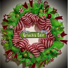 a green wreath with red and white candy canes on it that says grin's fair