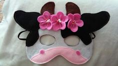 a white mask with pink flowers on it and a black cow's face in the middle