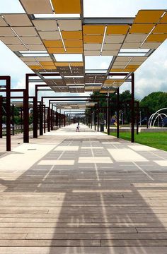 the walkway is lined with metal poles and yellow awnings