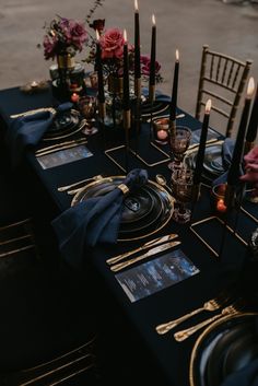 a table set with candles, plates and napkins