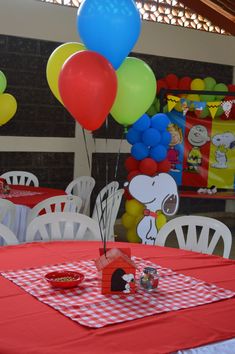 a table topped with lots of balloons next to a red and white checkered table cloth