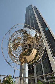 a large metal sculpture in front of a tall building