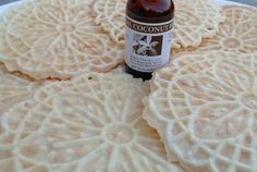 a bottle of alcohol sitting on top of some crackers that have been cut into circles