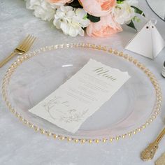 a place setting with gold beaded plates and flowers