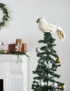 a white bird sitting on top of a christmas tree