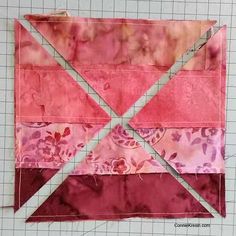 a piece of pink and red fabric on top of a cutting board