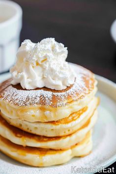 a stack of pancakes topped with whipped cream