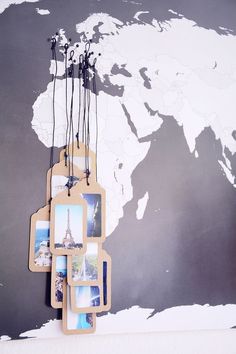 a world map hanging on the wall with some pictures attached to it's sides