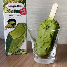 a green ice cream in a glass bowl next to a box of matcha pods