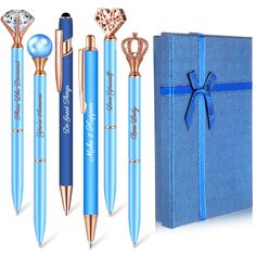 a blue gift box with three pens, two diamond rings and a ring on it